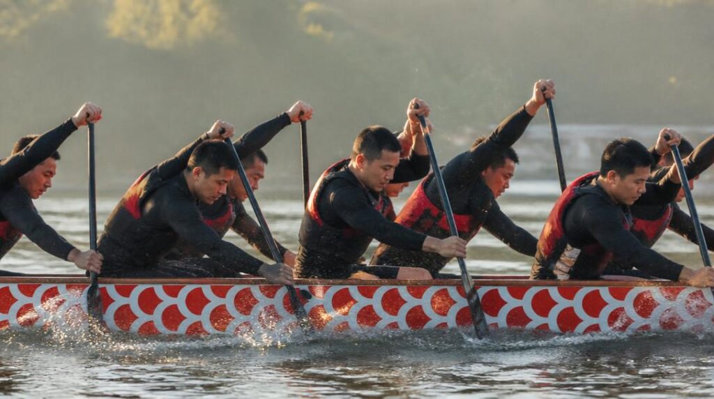 Équipe de dragon boat pagayant sur l’eau